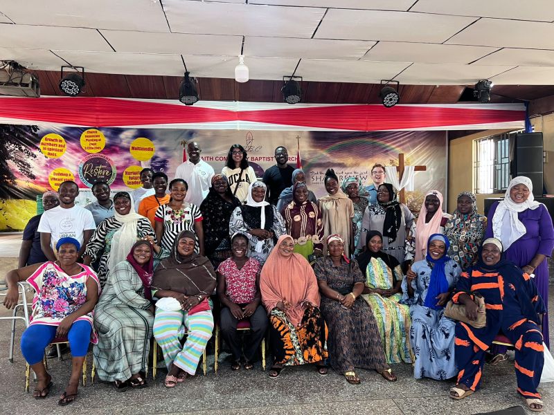 A group of women sitting and standing for a photograph