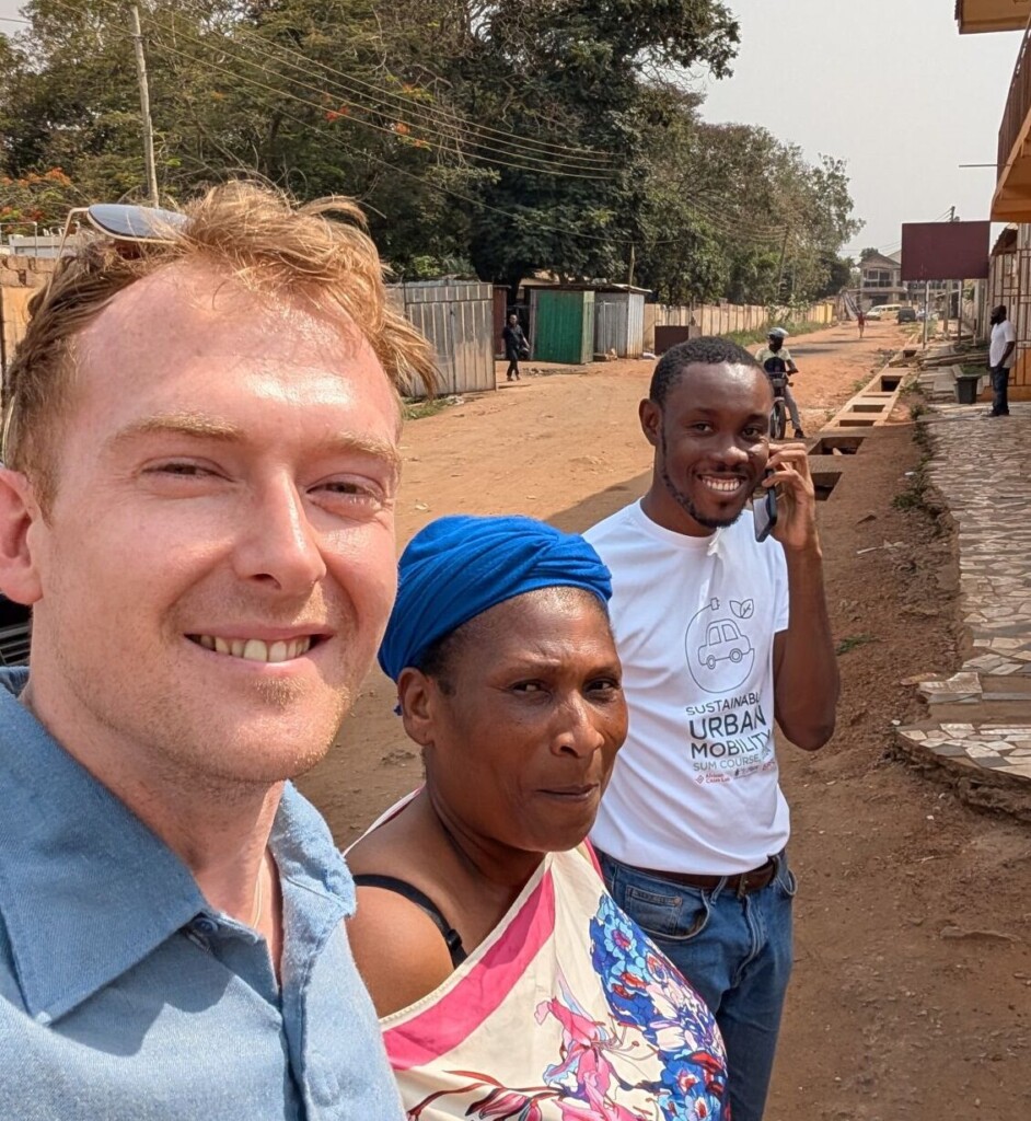 A smiling white man with two black people