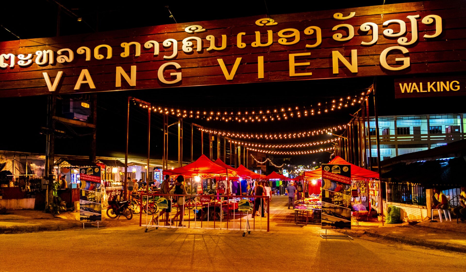 a street at night with lots of lights strung across it.