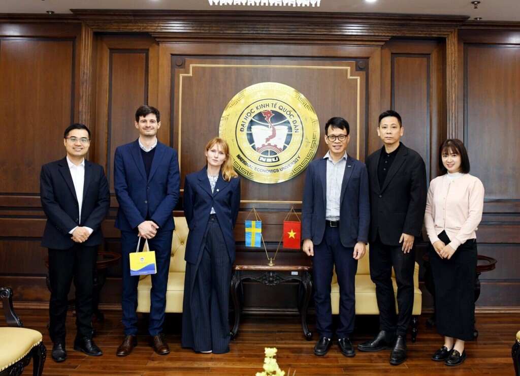 six people standing in a dark wood panelled room