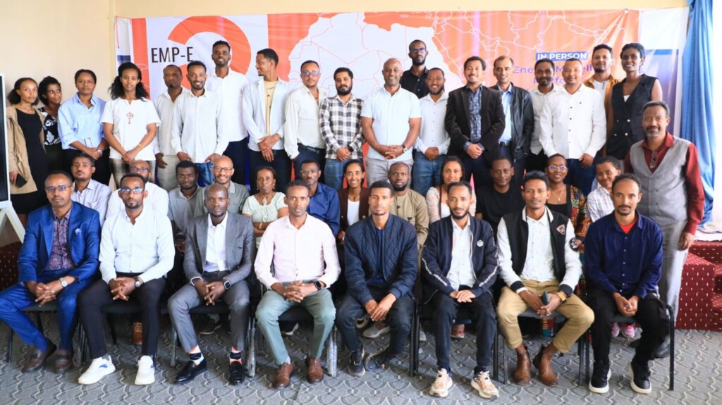 a large group of Ethiopian people post in front of an orange sign.