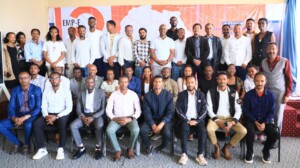 a large group of Ethiopian people post in front of an orange sign.