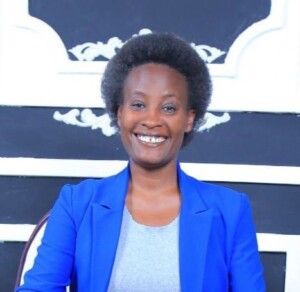 a black woman smiling and dressed in a blue jacket
