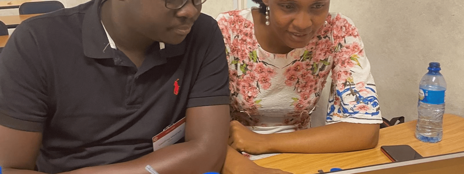 An image of two participants working at the Summer School in front of a laptop