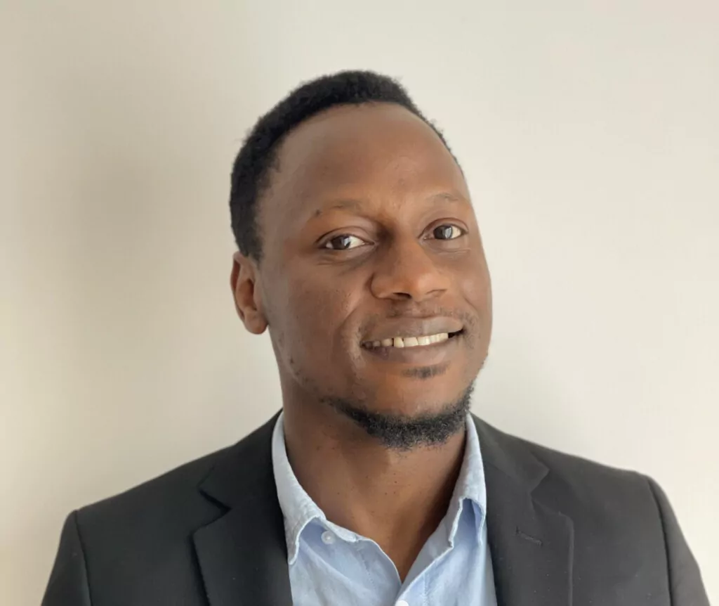 A smiling Afro-Caribbean man with a short beard
